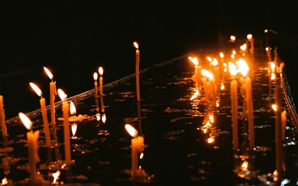 A collection of candles flickering softly on a wooden table.