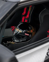 Close-up of a custom motorsport decal being carefully applied to a racing helmet.