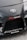 The image features the front part of a car with a focus on the bumper and grill area. Prominently displayed is the Toyota logo in the center of the car's hood. Nearby, there are several decals, including the words 'TENACI Parts for Racecars' in white with a red gear graphic, and 'altigarasjen.no' along with the 'Pandem' logo.