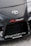 The image features the front part of a car with a focus on the bumper and grill area. Prominently displayed is the Toyota logo in the center of the car's hood. Nearby, there are several decals, including the words 'TENACI Parts for Racecars' in white with a red gear graphic, and 'altigarasjen.no' along with the 'Pandem' logo.