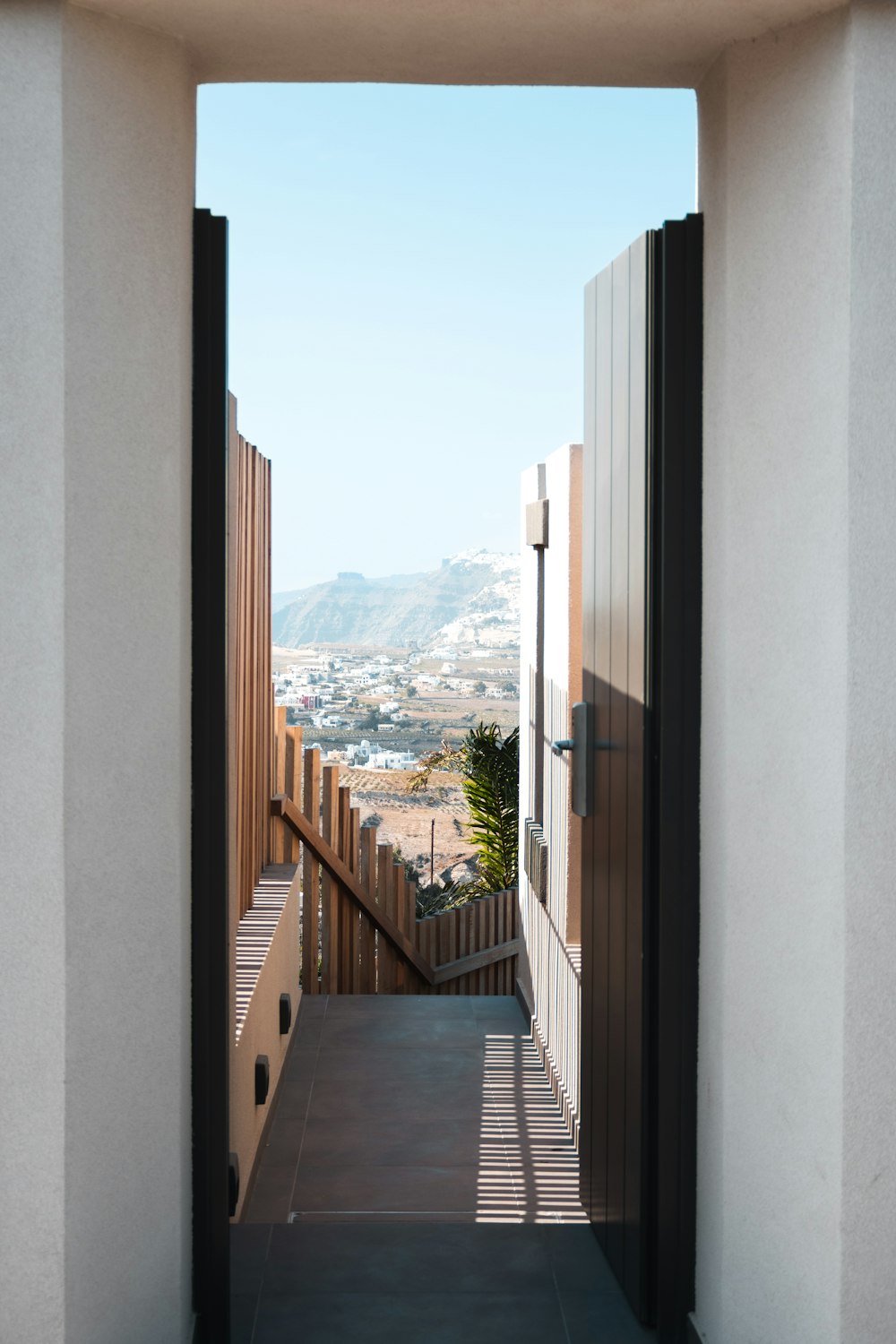 an open door leading to a balcony with a view of a city
