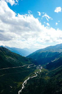 View of the Sacred Valley river winding through towering mountains under a vibrant blue sky