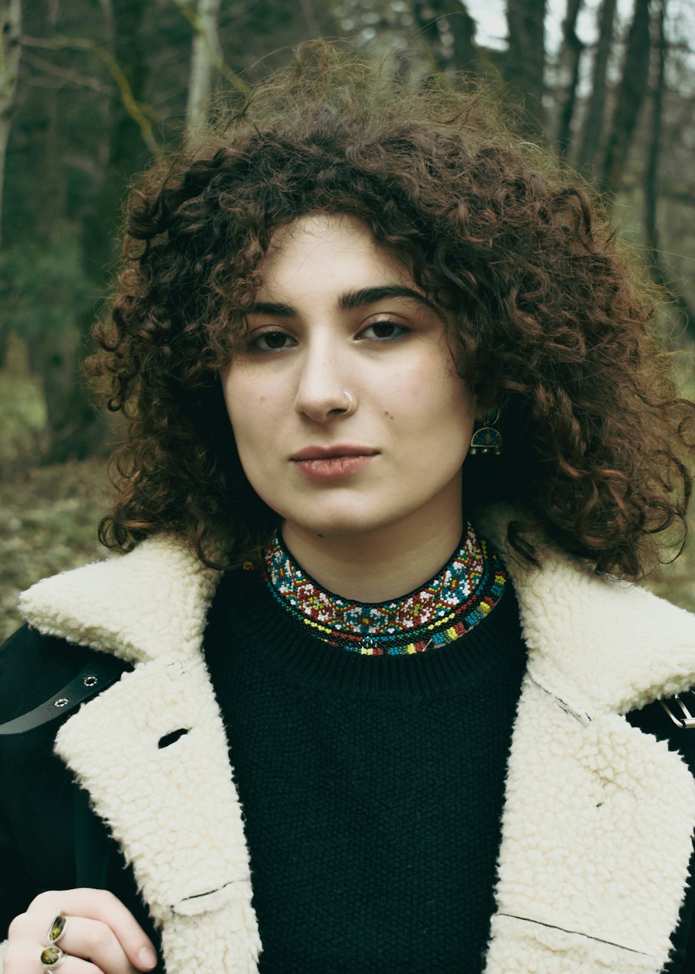 a woman with curly hair wearing a jacket