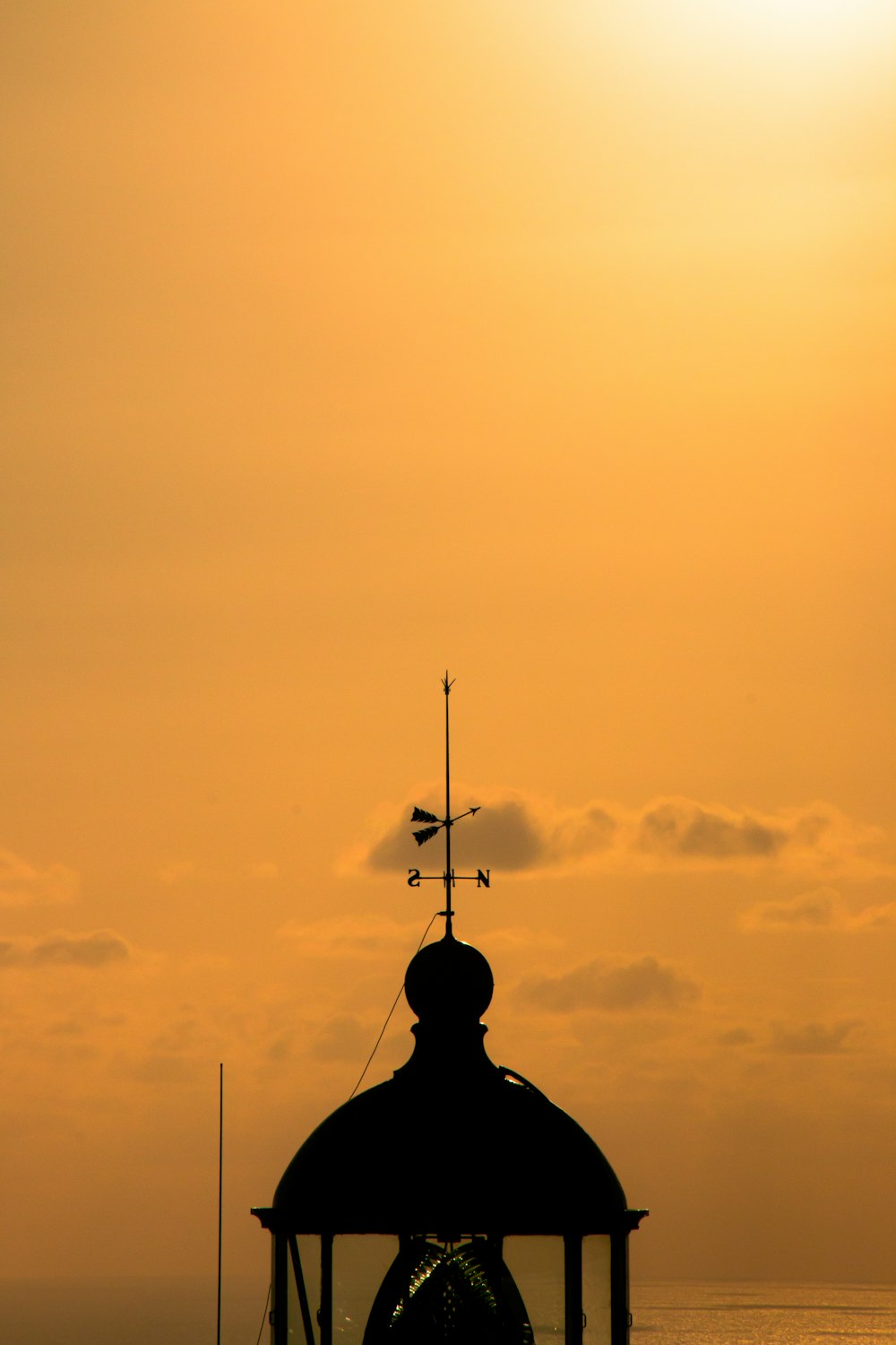 the sun is setting over the water and a clock tower