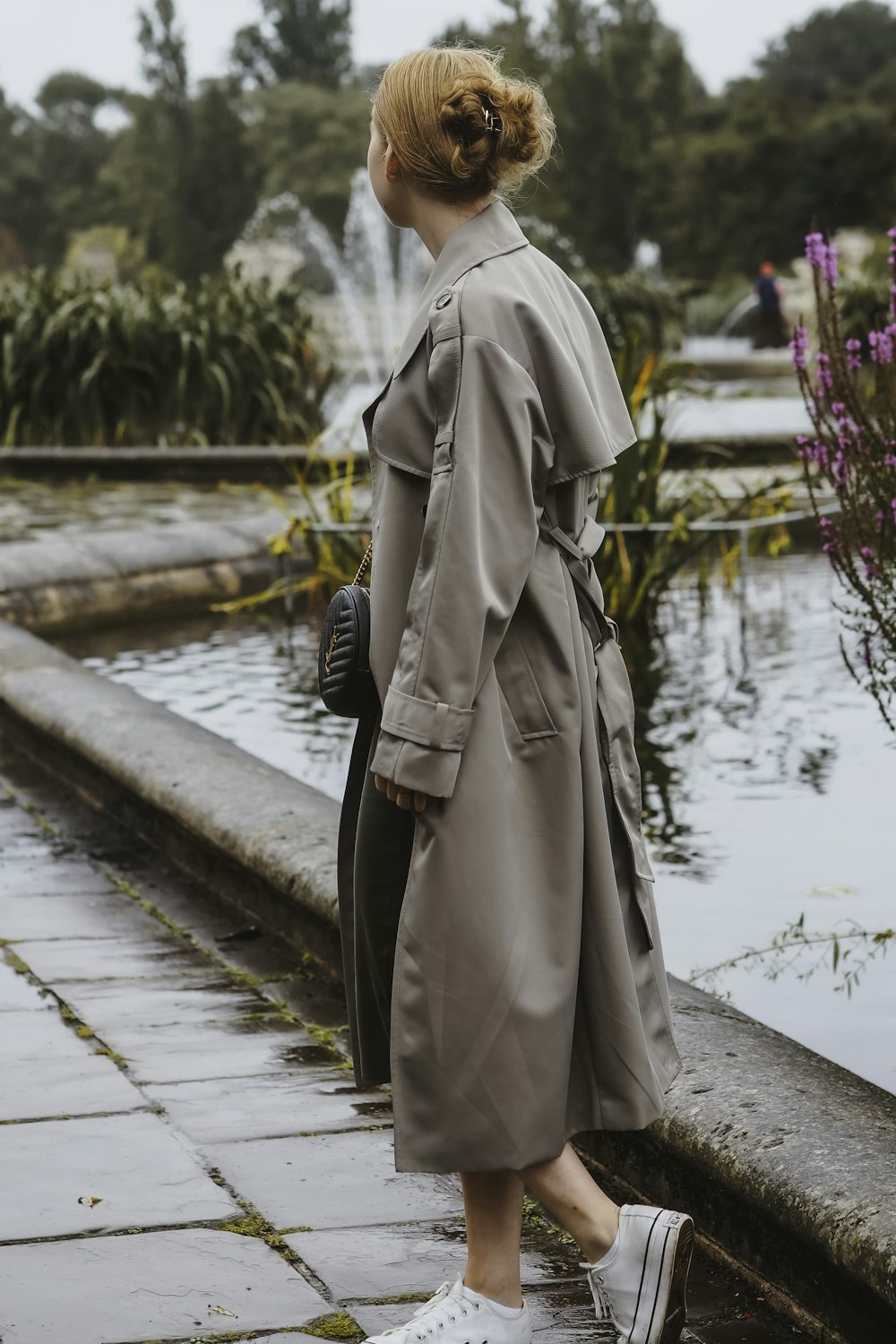 a woman standing in front of a fountain