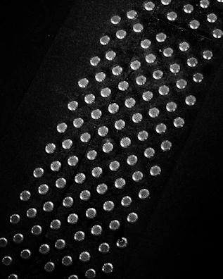 Ultra cool silver studs with a subtle shine placed on a textured fabric.