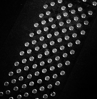 a black and white photo of a tie with lots of dots on it