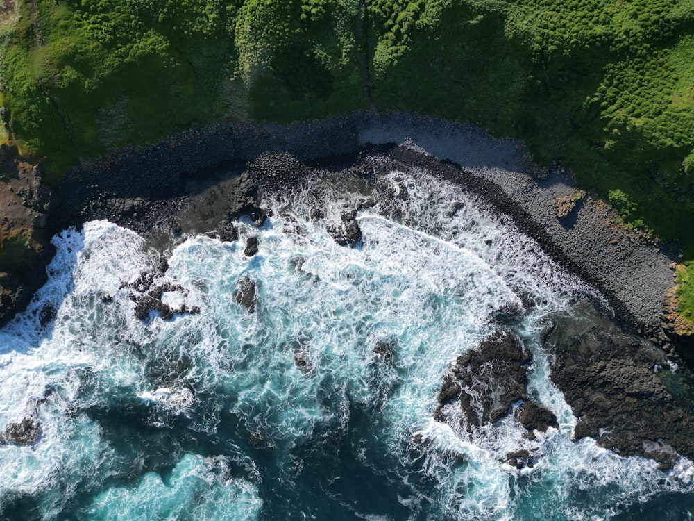 an aerial view of a body of water surrounded by rocks