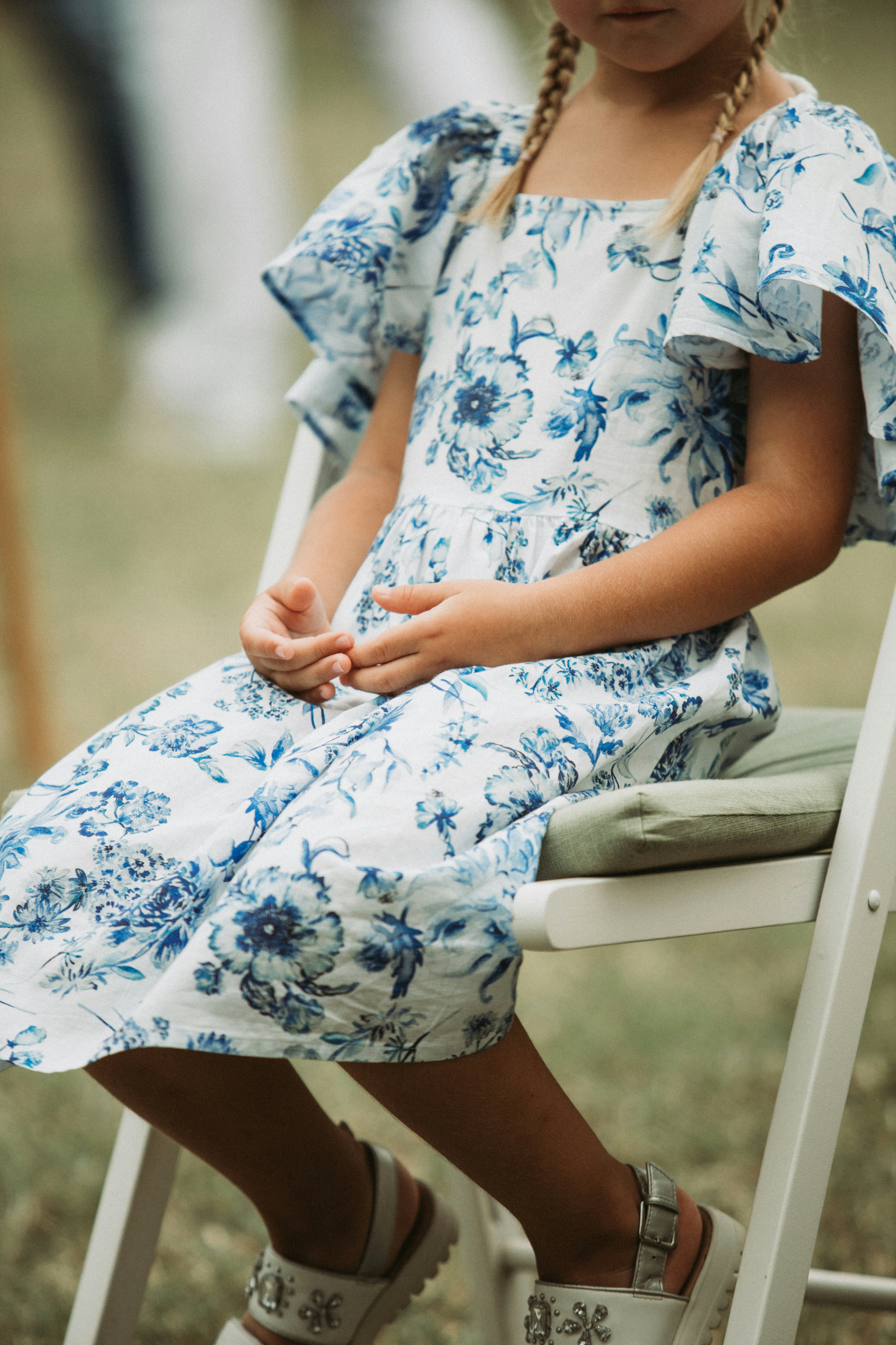 a little girl sitting on a white chair