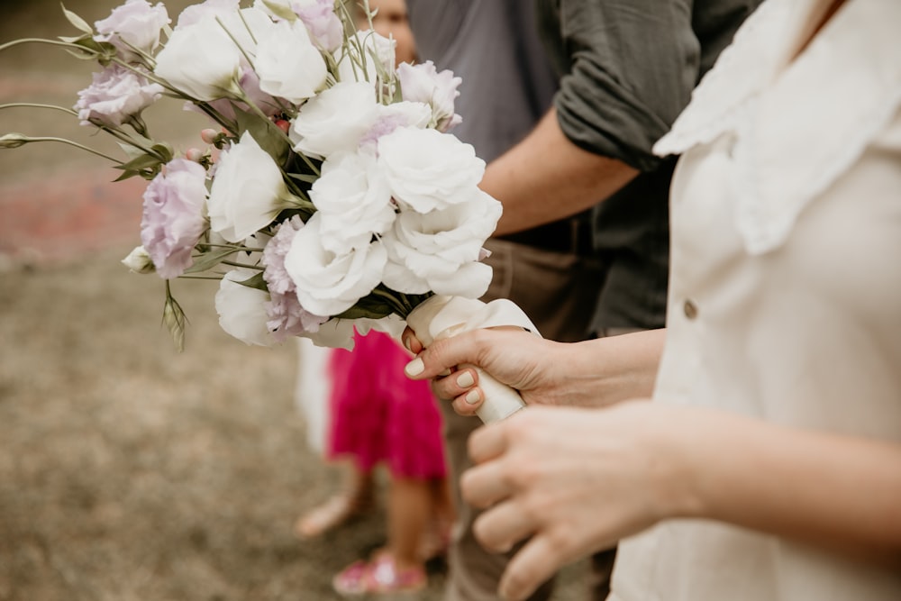 a close up of a person holding a bouquet of flowers