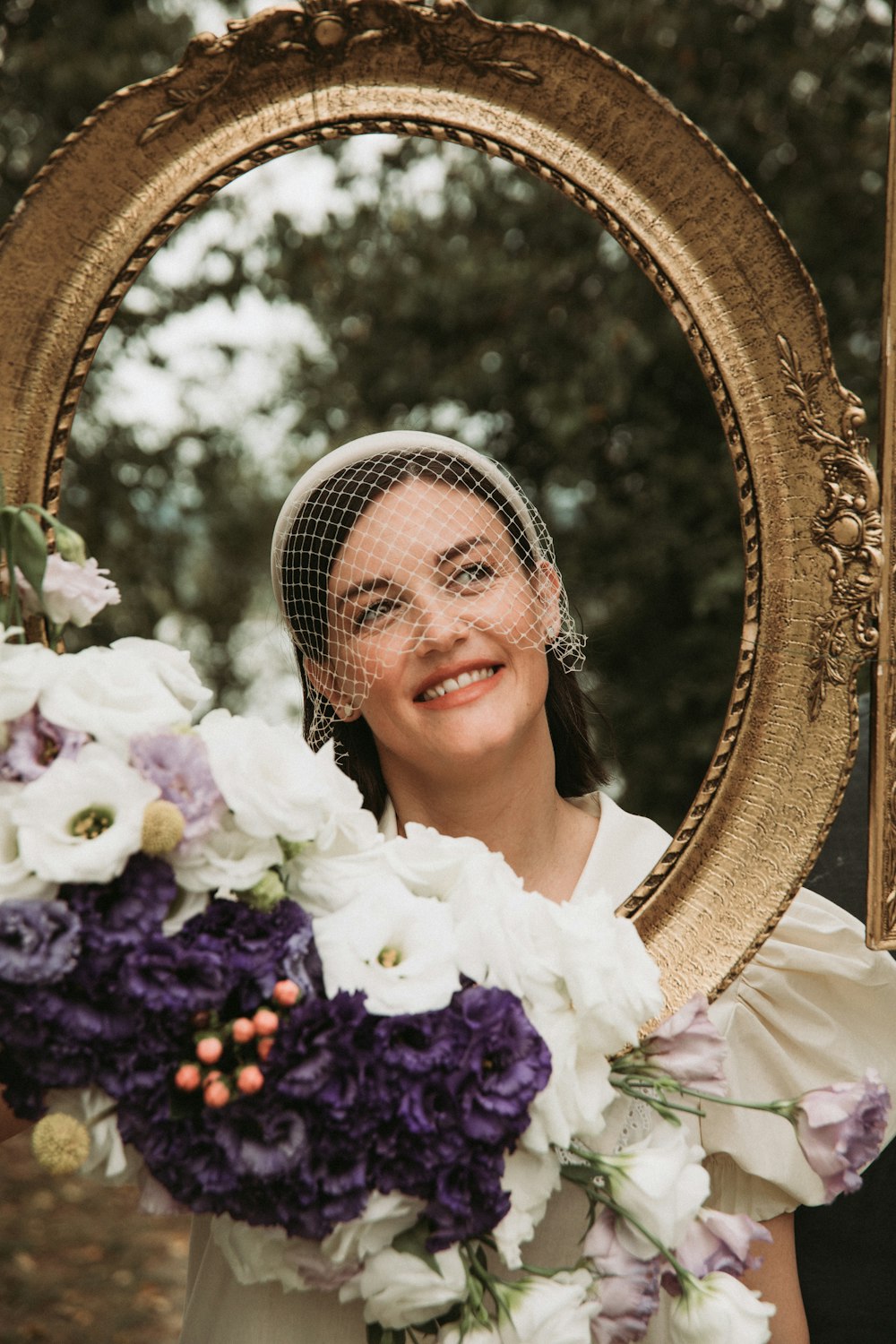 a woman holding a bouquet of flowers in front of a mirror