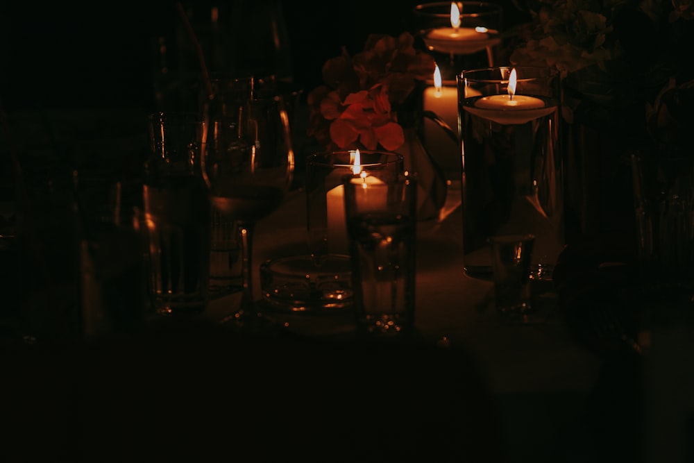 a table topped with lots of candles and wine glasses