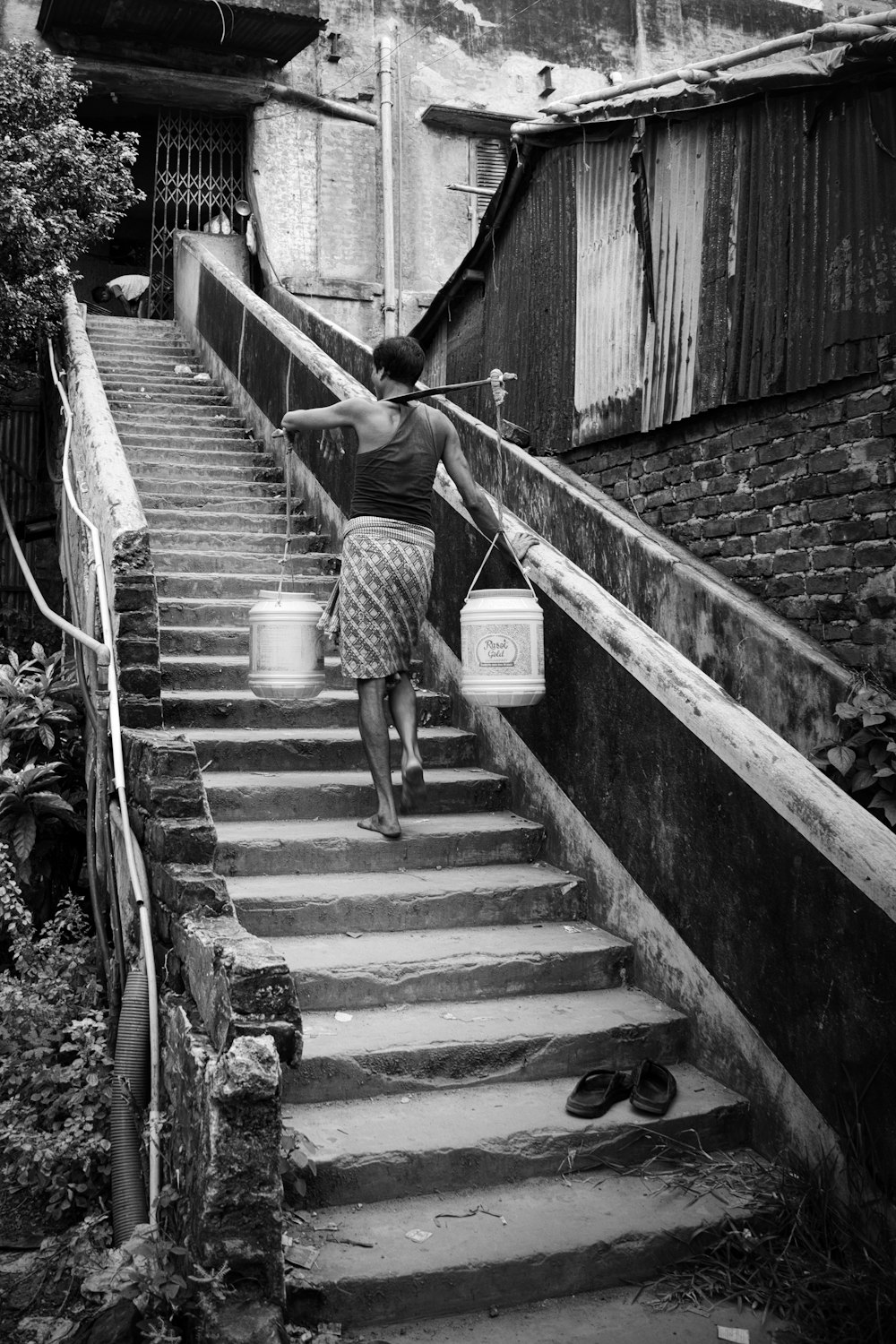 a woman carrying a bucket down a flight of stairs