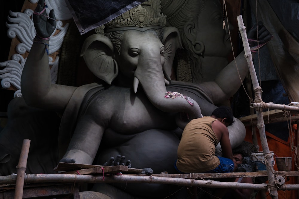 a man working on a statue of an elephant