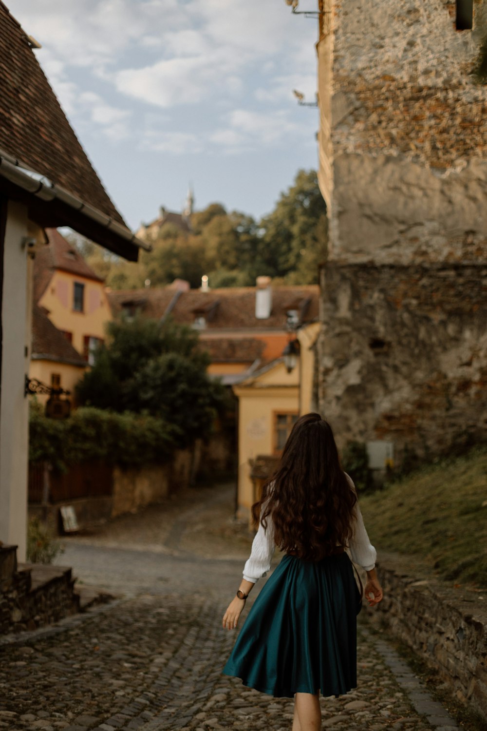 a woman walking down a cobblestone street