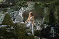 Athlete practicing breathing exercises surrounded by volcanic rock textures and soft orange light of sunrise.
