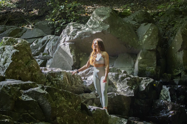Athlete practicing deep breathing surrounded by high mountain grasses and volcanic rock textures.