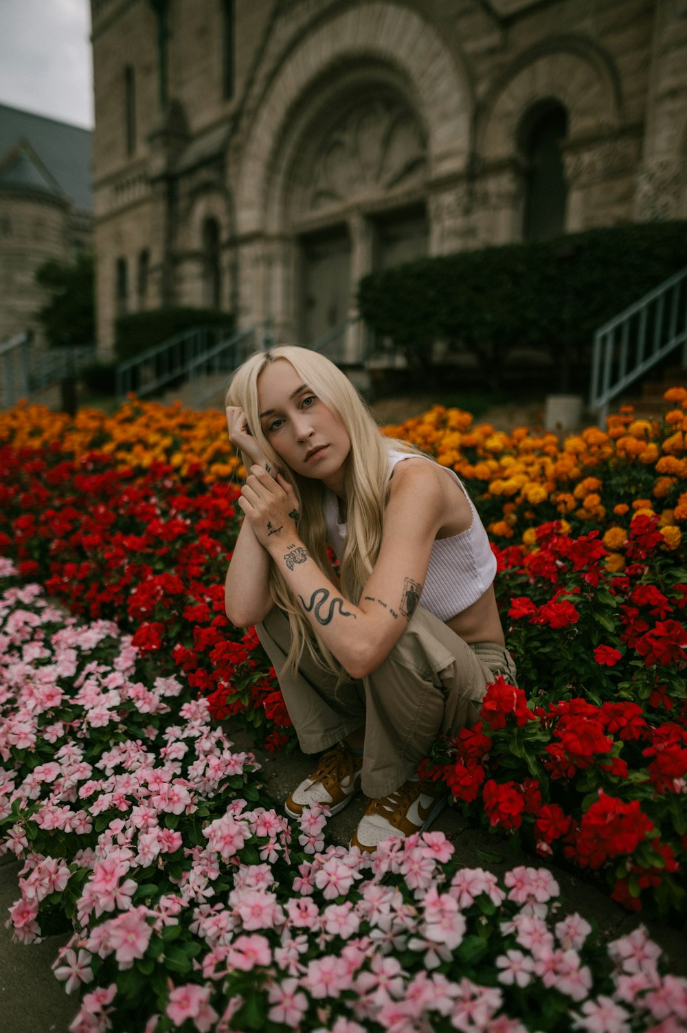 a woman kneeling down in a field of flowers