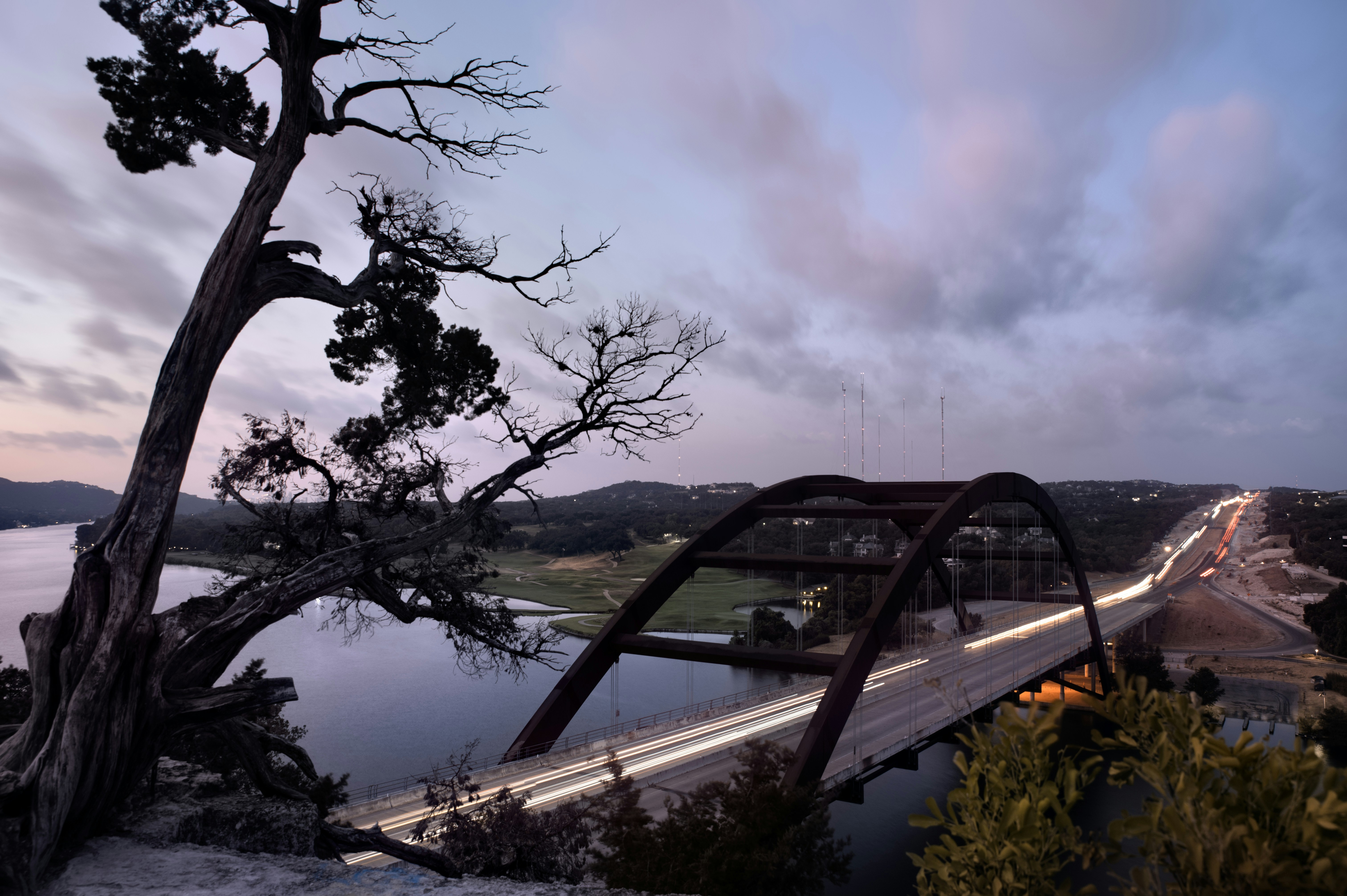 a bridge over a body of water at dusk, 