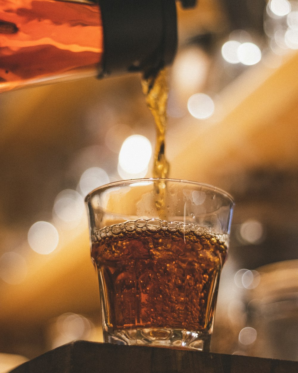 a glass filled with liquid being poured into it