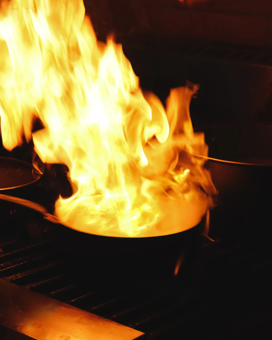 Pan engulfed in tall flames over a grill