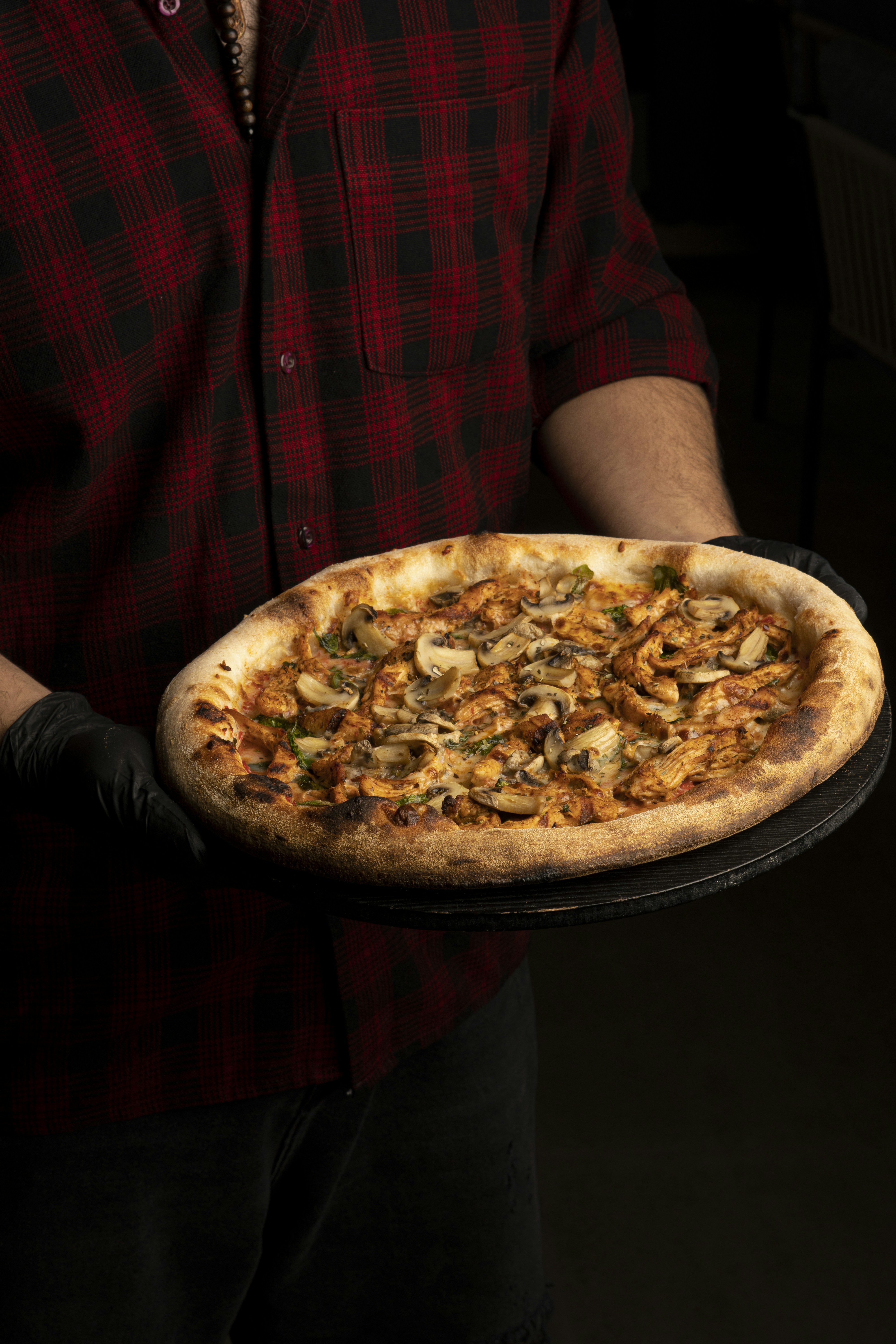 a man is holding a pizza on a tray