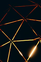 Artistic photo of a sacred geometry pattern softly illuminated with golden light.