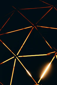 Close-up of ancient sacred geometry patterns glowing softly in antique gold on a deep indigo background.