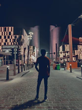 Architect examining outdoor lighting fixtures during twilight in an urban park.