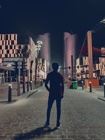 Architect examining outdoor lighting fixtures during twilight in an urban park.