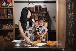Gris’s two daughters joyfully helping to prepare homemade tamales in a cozy kitchen.