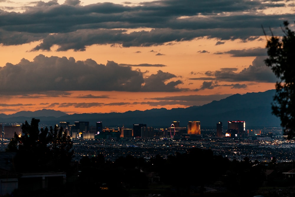 a view of a city at sunset with clouds in the sky