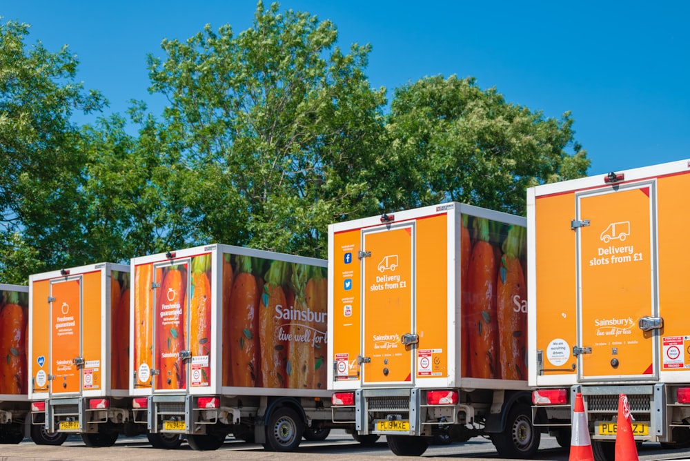 a row of orange delivery trucks parked next to each other