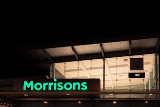 a neon sign that reads morrisons in front of a building