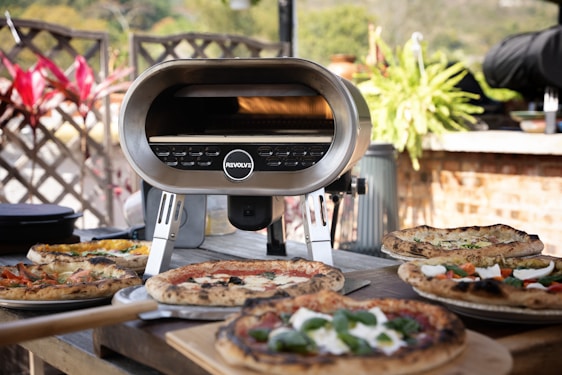 Cozy wood-fired pizza oven with a rustic outdoor fountain surrounded by greenery