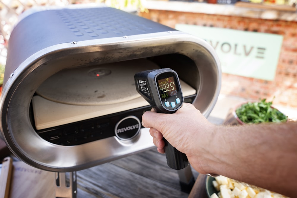 a person is checking the temperature of a grill