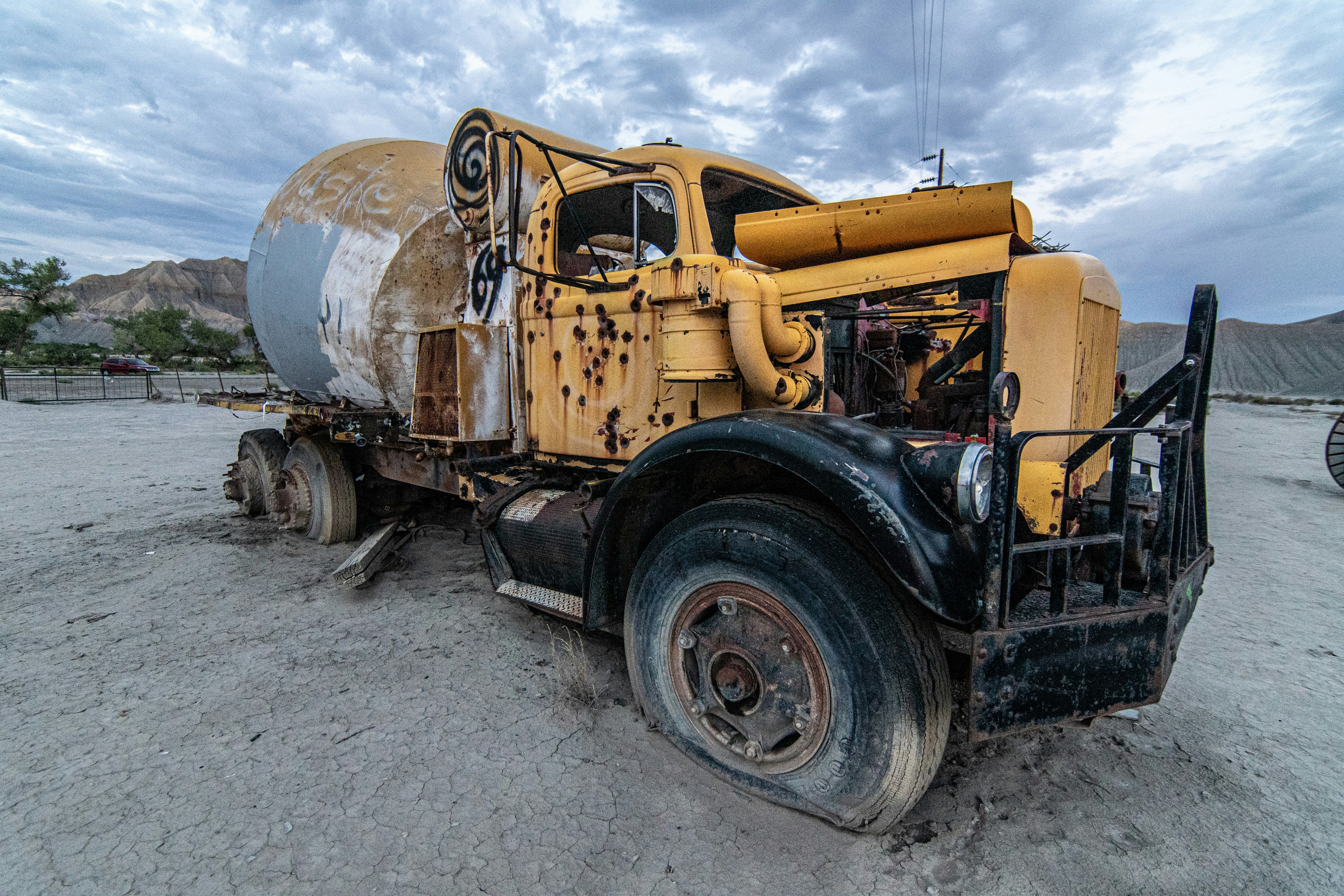 a large yellow truck parked on top of a dirt field