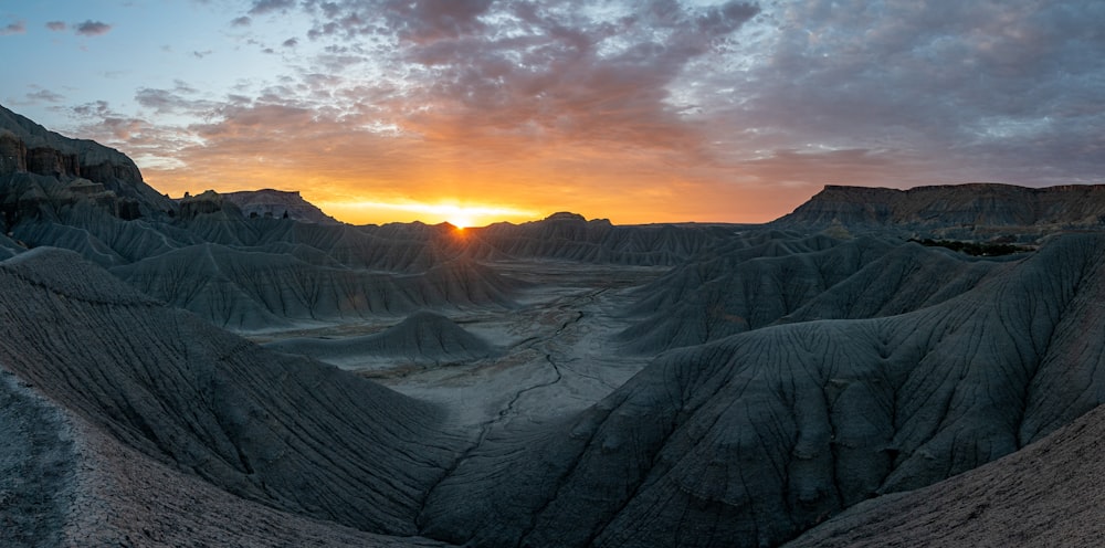 the sun is setting over the mountains in the desert