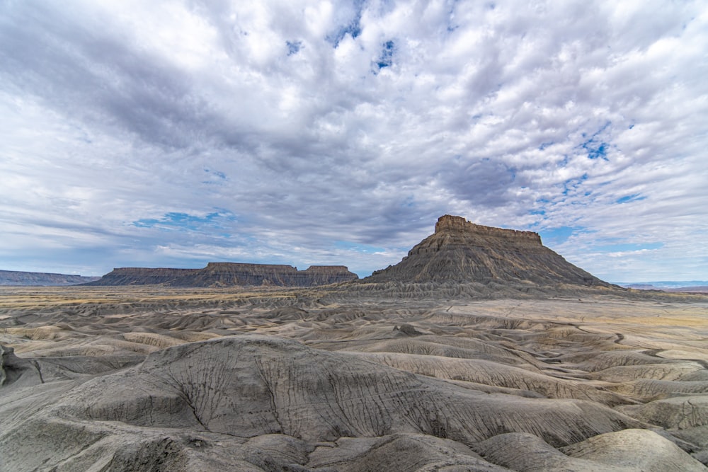 a desert landscape with a mountain in the background