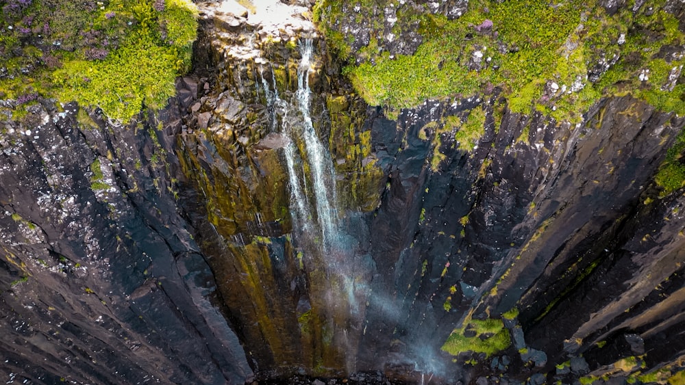 an aerial view of a waterfall surrounded by moss