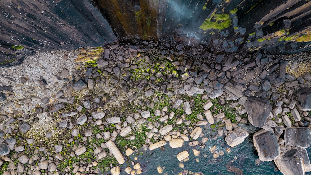 an aerial view of rocks and water near a waterfall
