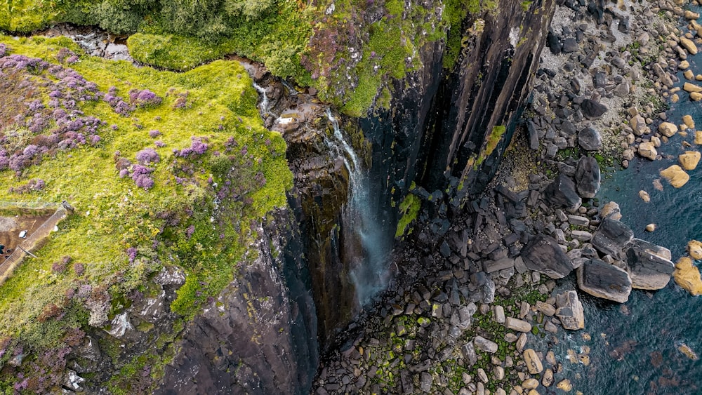 an aerial view of a waterfall in the middle of the ocean