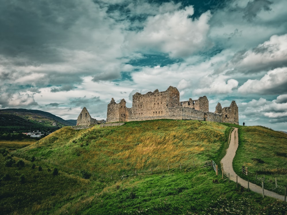 a large castle sitting on top of a lush green hillside