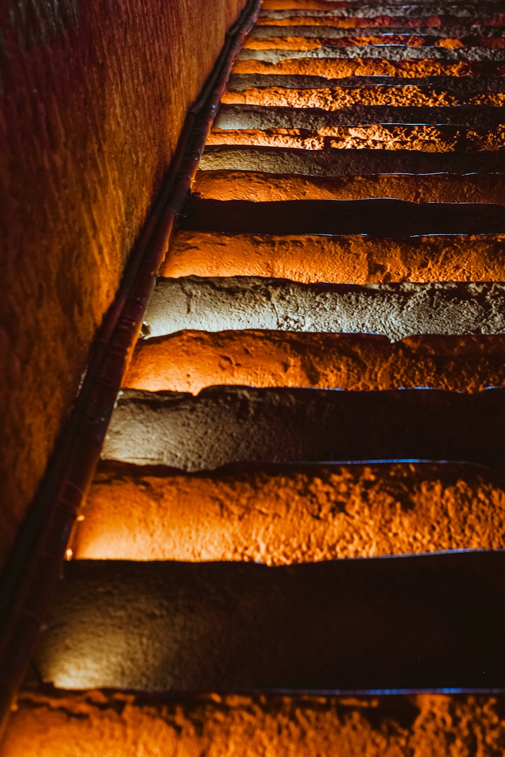 a long row of lit candles in a dark room