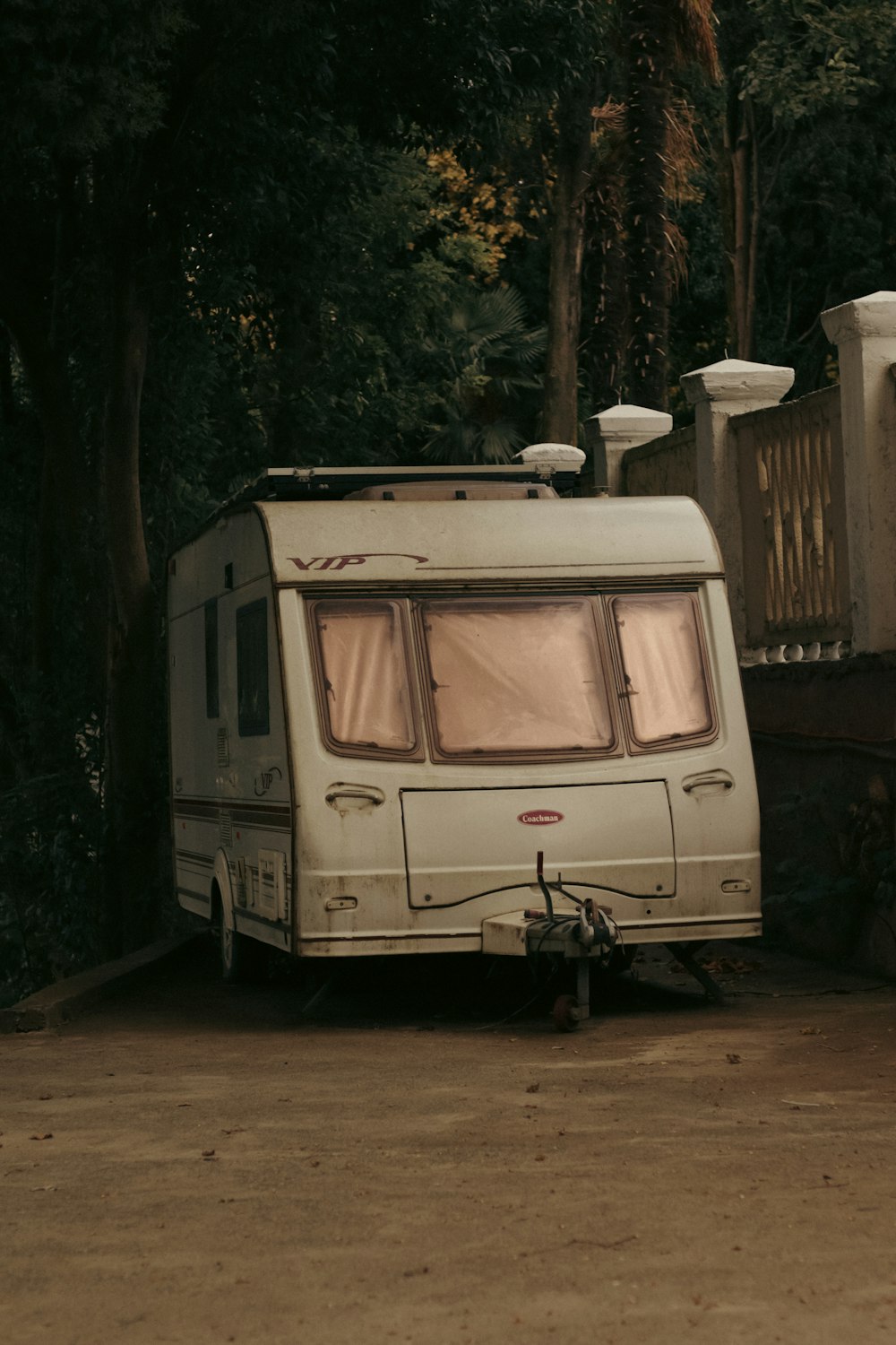 a white trailer parked in front of a forest