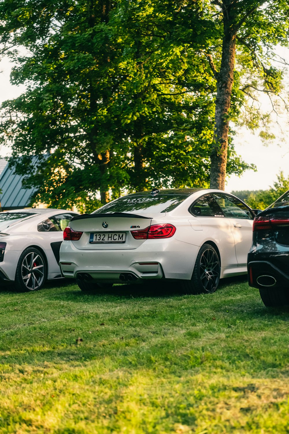 a couple of cars parked next to each other on a lush green field