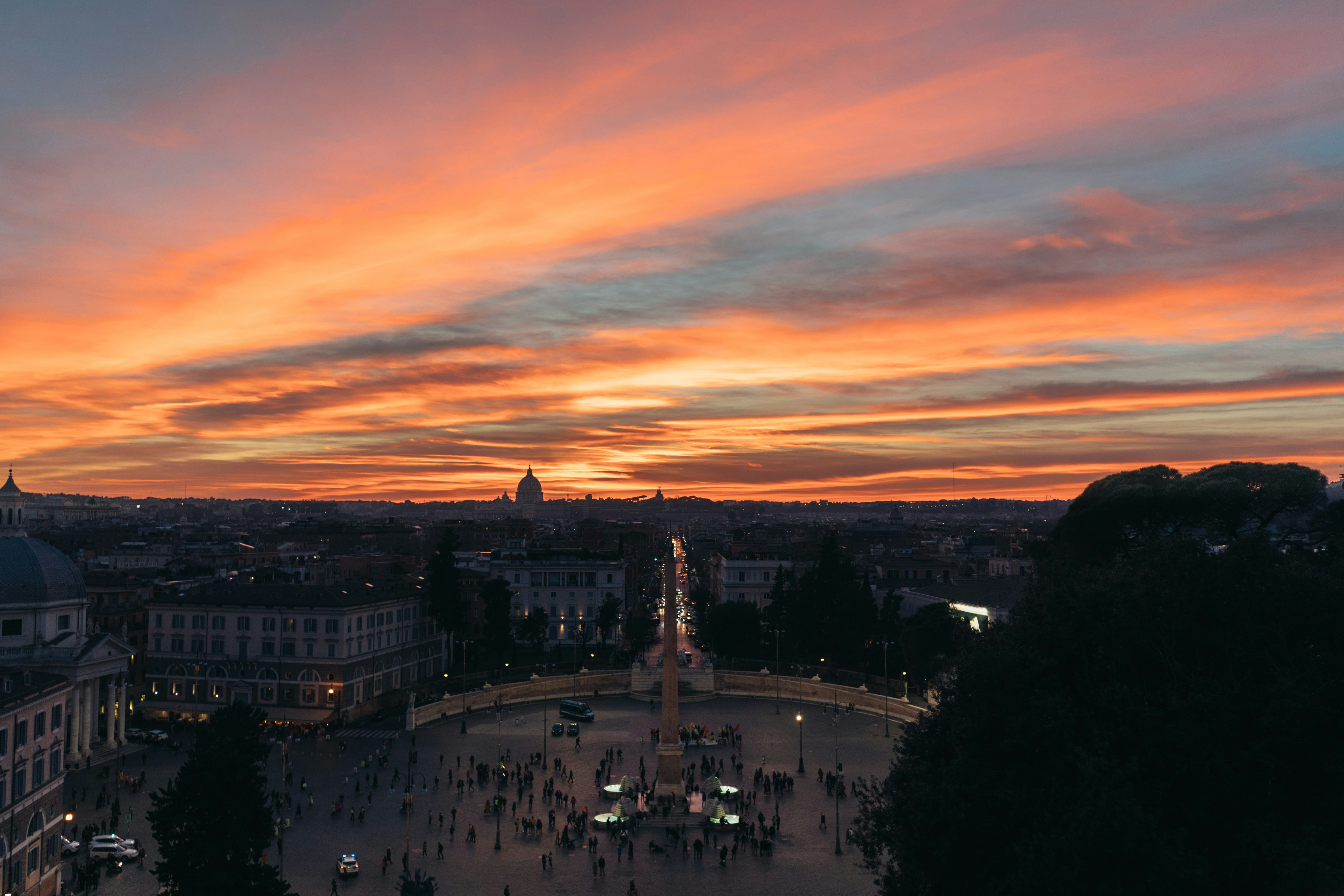 a view of a city at sunset from the top of a building, Sunset at Piazza del Popolo, Rome, Italy