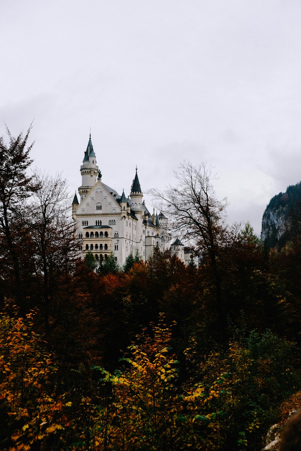 a large white castle sitting on top of a lush green hillside