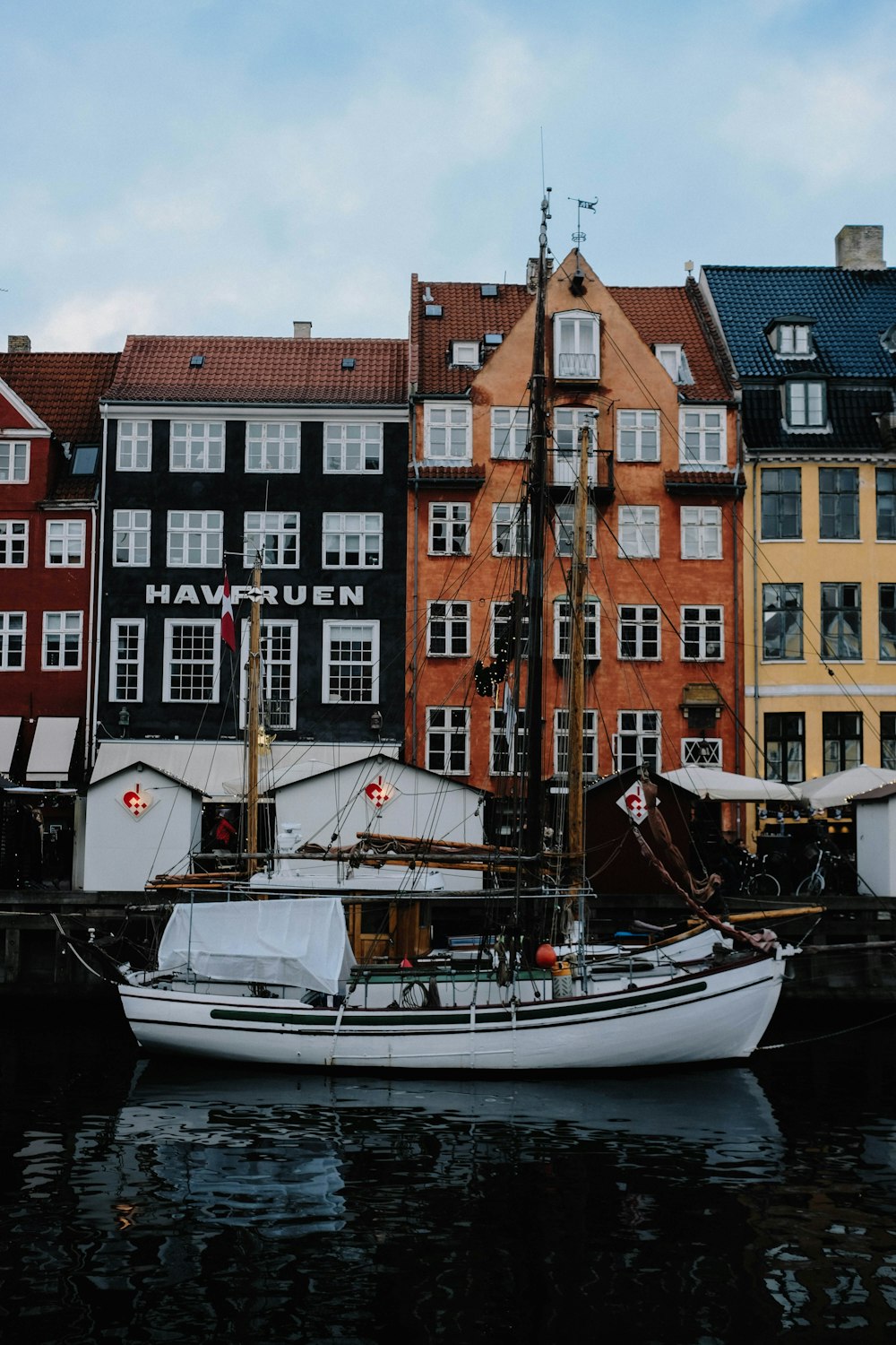 a boat is docked in front of a row of buildings