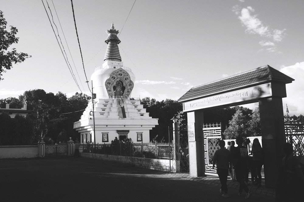 a black and white photo of people walking in front of a building